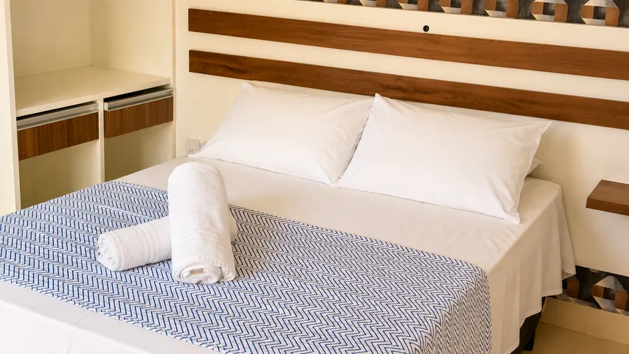 Detalle de la cama con ropa de cama y toallas