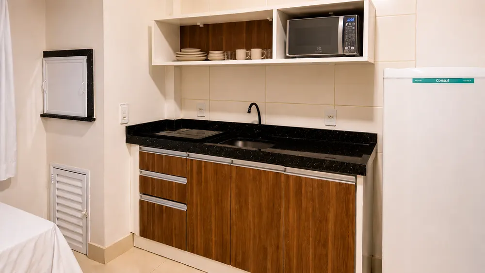 Cocina equipada con encimera, fregadero, microondas y armarios
