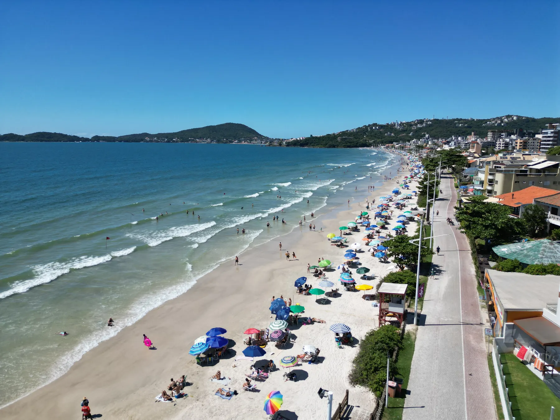 Playa de Bombas en un día soleado, con sombrillas de colores y mar tranquilo, en Bombinhas - SC